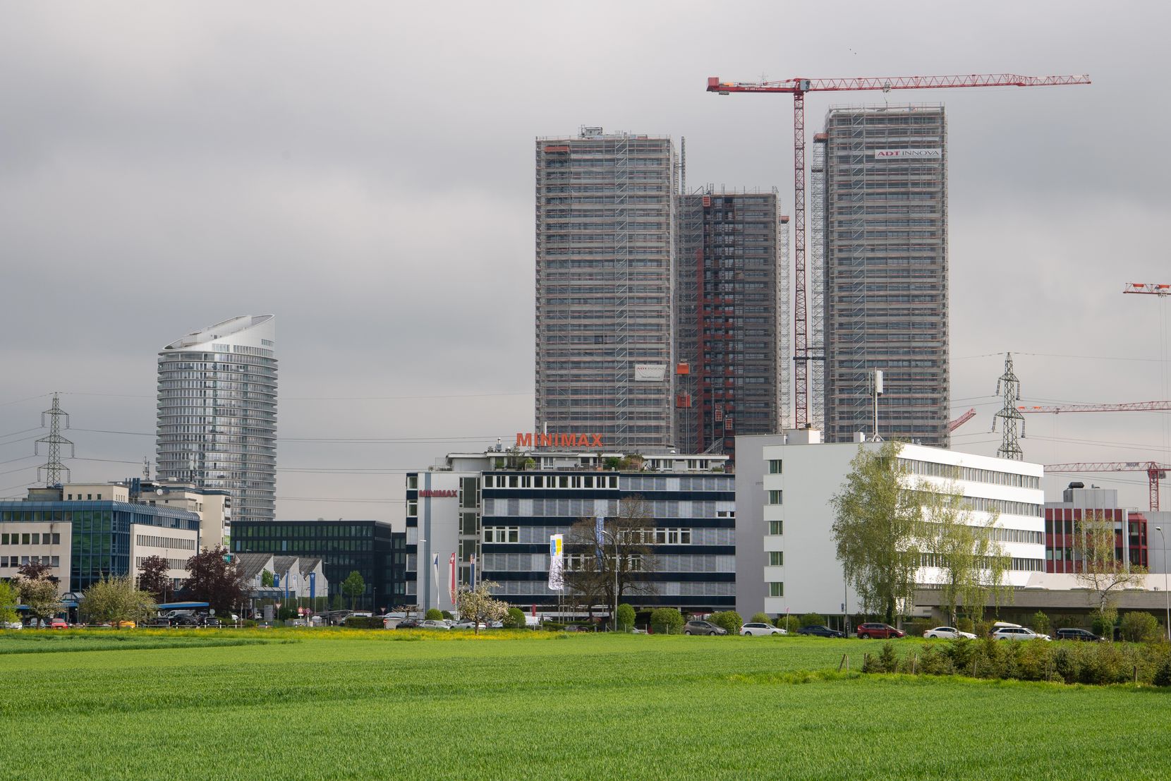 Eine Wiese und ein paar Hochhäuser.